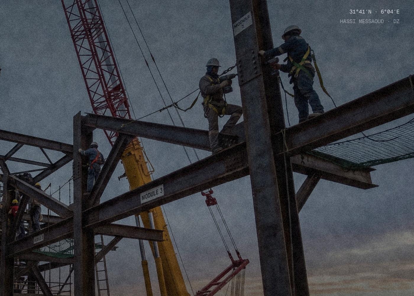 Steel erection at dusk on the ABP Continental home page: riggers bolting a column against a crawler crane, map coordinates printed in the corner.