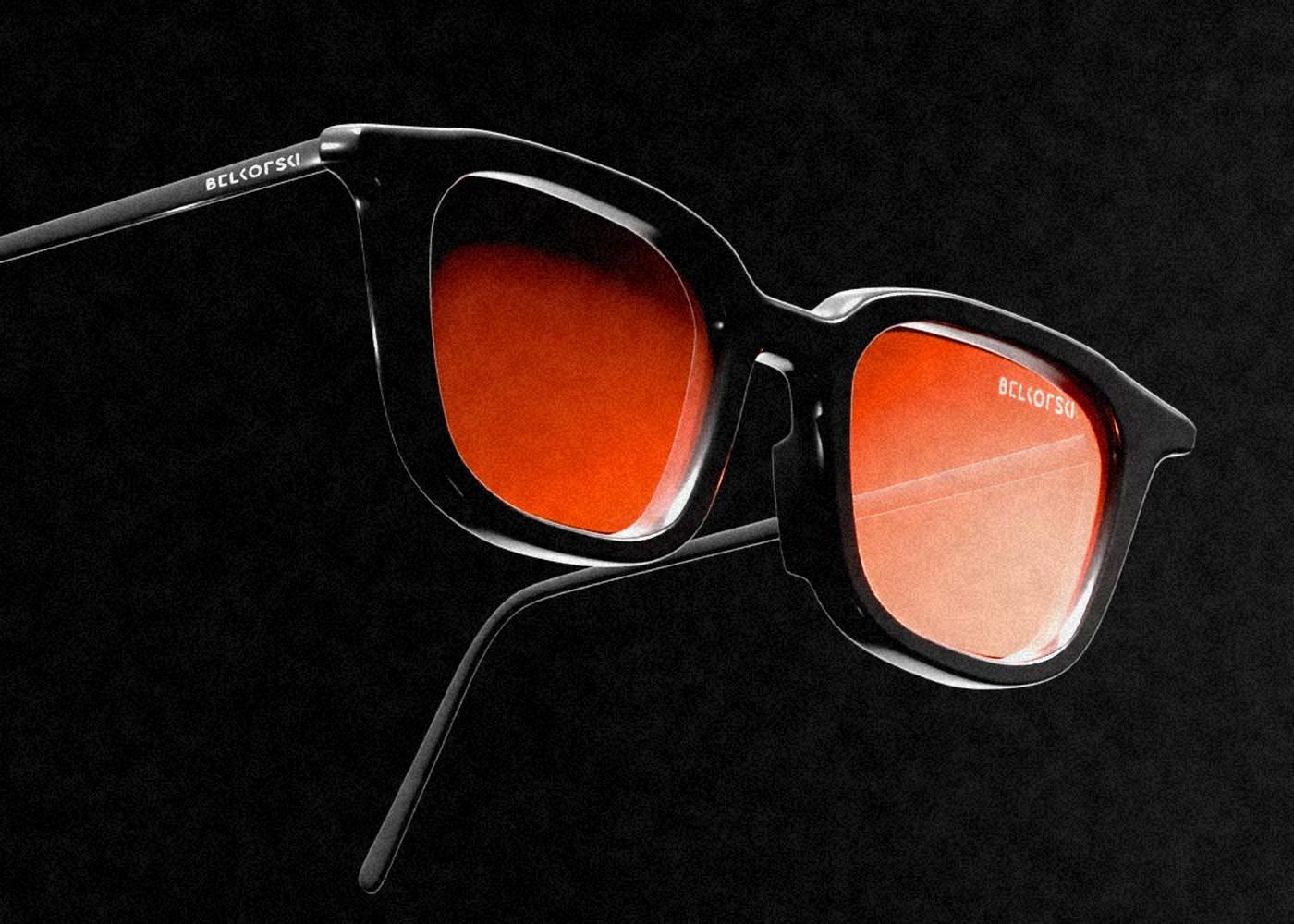 A pair of Belkofski frames on black, the lenses in a deep orange gradient, the name set inside the lens and along the temple arm.