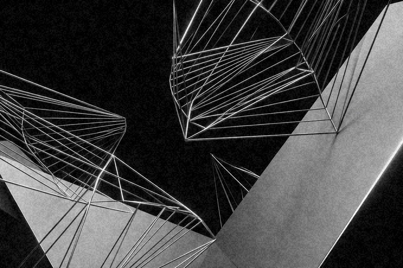 A monochrome render: wireframe polyhedra and solid white planes suspended against black.